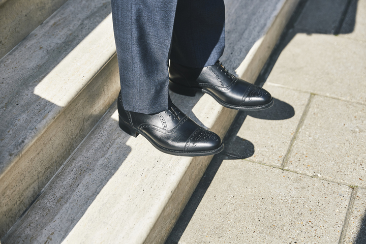 Black Oxford shoes on stone step