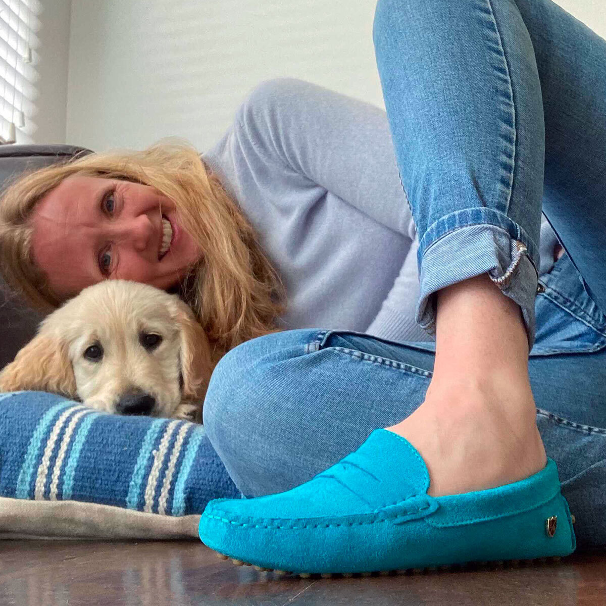 Woman in turquoise loafers with puppy