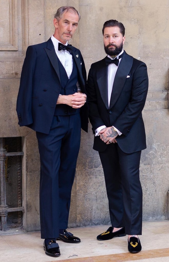 Men in black tie with bearded man on right also wearing Herring Stag slipper men's house shoes in black velvet 
