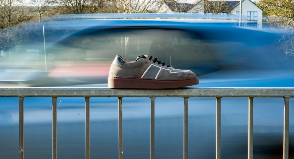 Herring Metz men's in grey multi sneakers perched on a railing